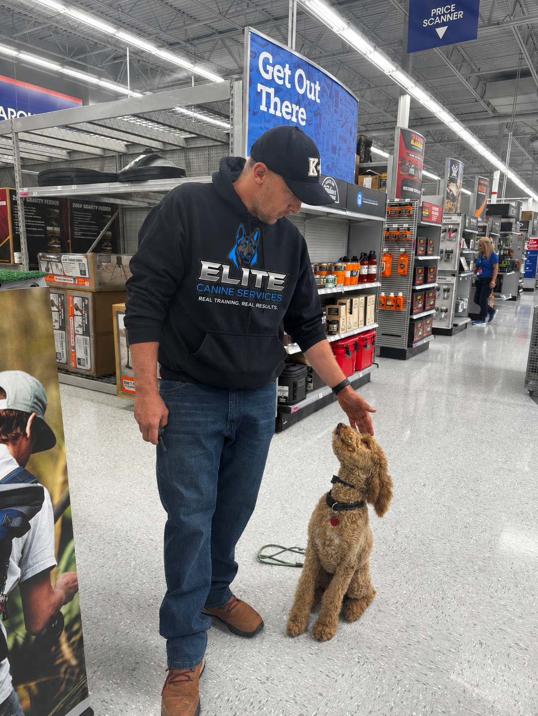 Trainer working with a Goldendoodle during public training in a retail store